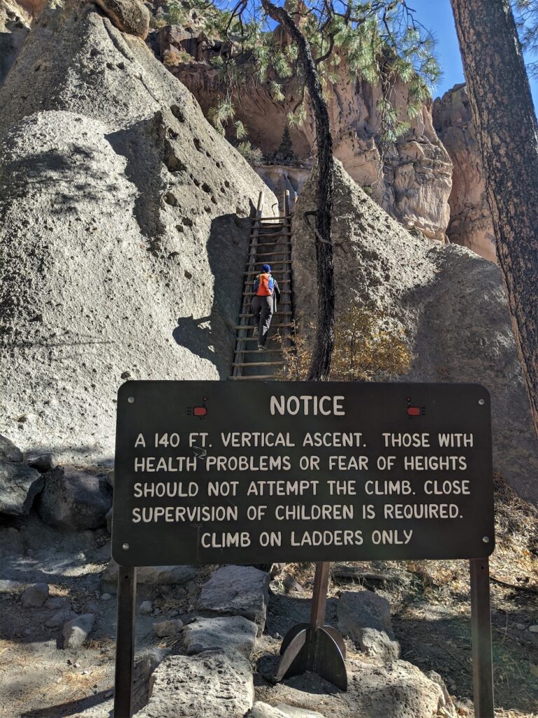 climbing a kiva ladder at Bandelier National Monument
