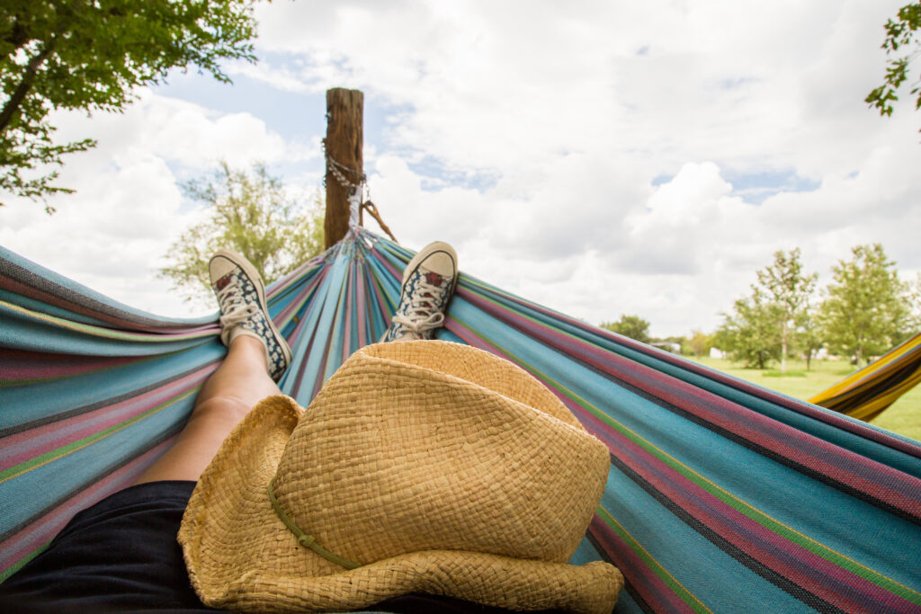 feet and a straw cowboy hat in a hammock