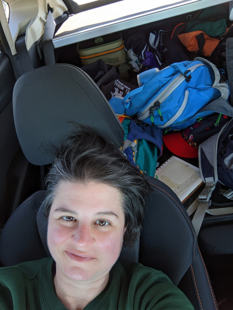 woman sleeping in a car on a camping trip