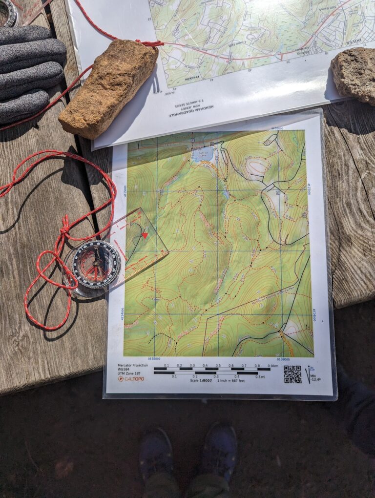 compass and topographical map on a picnic table