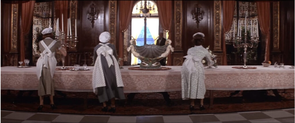 screenshot from the film Annie - servants in a dining room