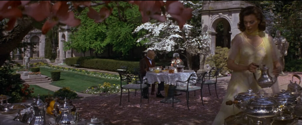 screenshot from the film Annie - outdoor gardens at the Warbucks Mansion
