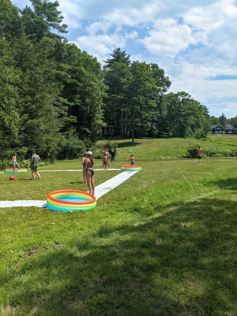 playing a game of kickball with slip and slide bases