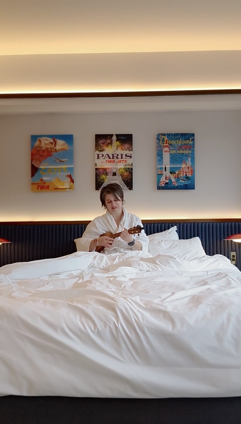 woman playing ukulele in a hotel room