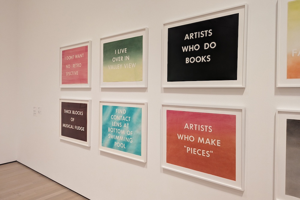 various Ed Ruscha pastel prints in a gallery