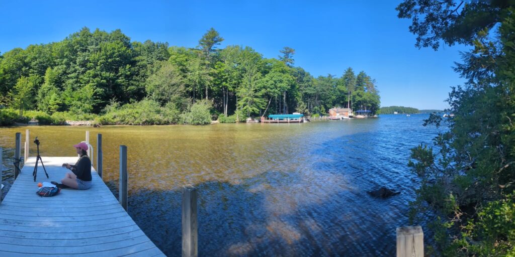 playing ukulele on a dock by Lake Winnipesaukee
